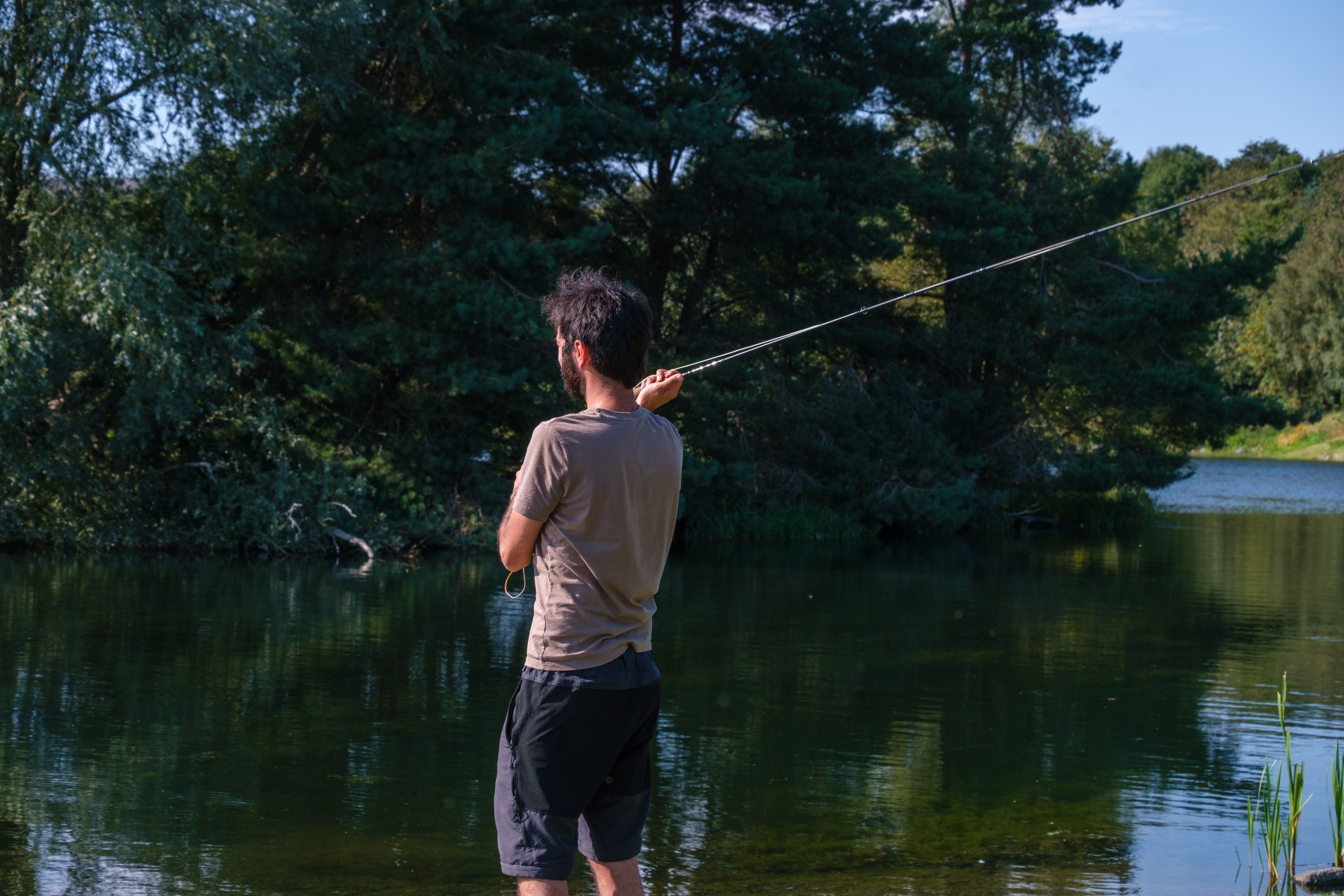 Angler casting a fly line on Loch Insch in summer