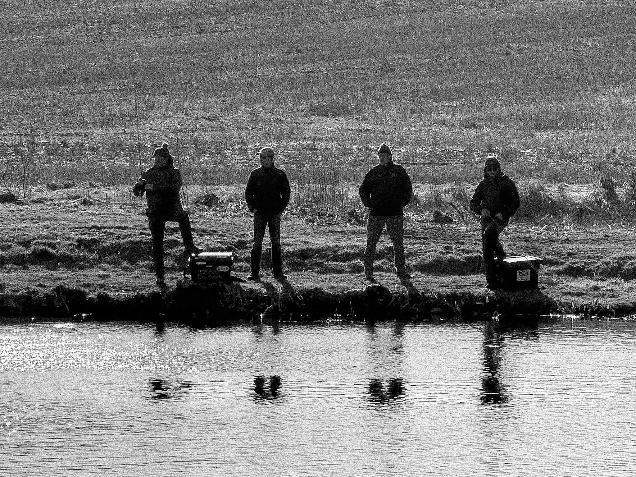 Vivid orange and red sunset silhouetting trees reflected in the loch