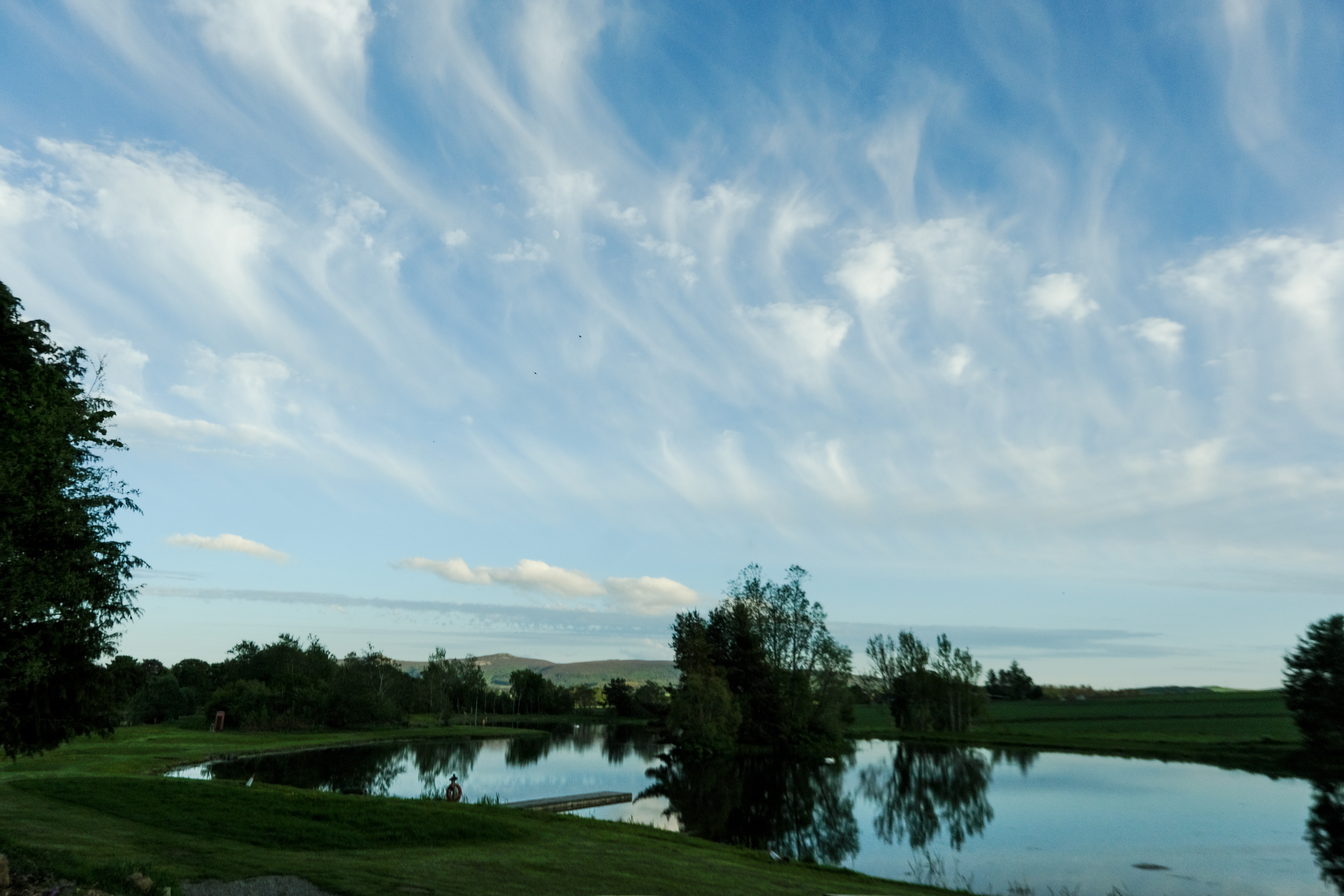 Loch Insch at dusk with Bennachie hills in the background and dramatic wispy clouds